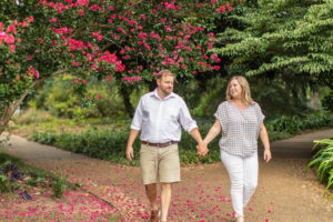 Couple walking during their engagement photos in fred fletcher park in raleigh north carolina