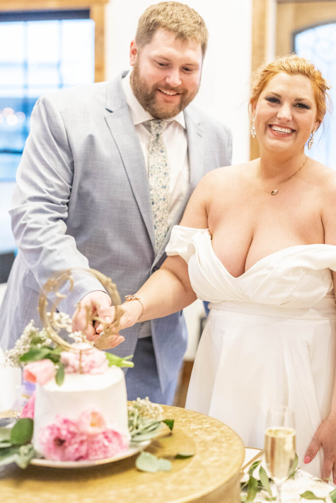 bride and groom cuts their wedding cake together